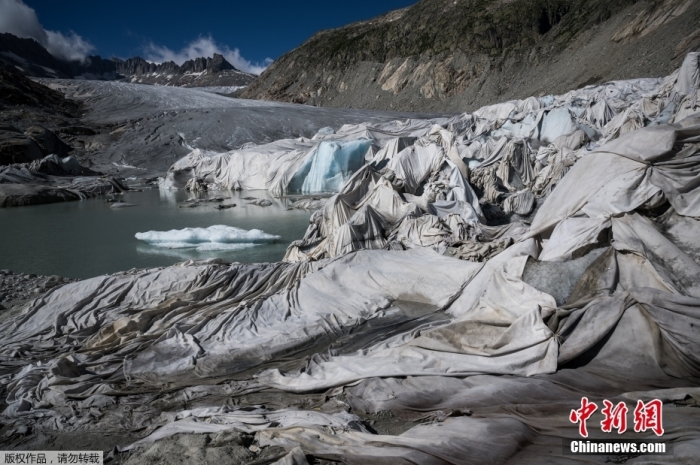 2022年7月14日消息，近日，瑞士阿尔卑斯山脉格莱奇附近，罗讷冰川被盖上纯白色的“毯子”。罗讷冰川是阿尔卑斯山脉最为古老的冰川之一，随着全球气候变暖，罗讷冰川的消融速度加剧。目前，冰川部分区域被盖上白毯，从而减缓冰川的融化速度。图为被白色“毯子”覆盖的罗讷冰川。