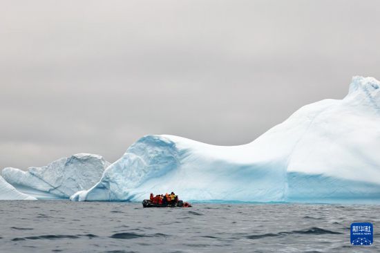 12月16日，探险者在南极洲拍摄海岸附近的冰山。新华社发（杨树摄）