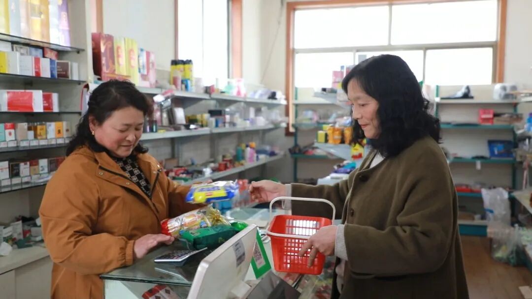 刘淑兰（右）通过积分在海娟超市兑换商品。王西辉摄